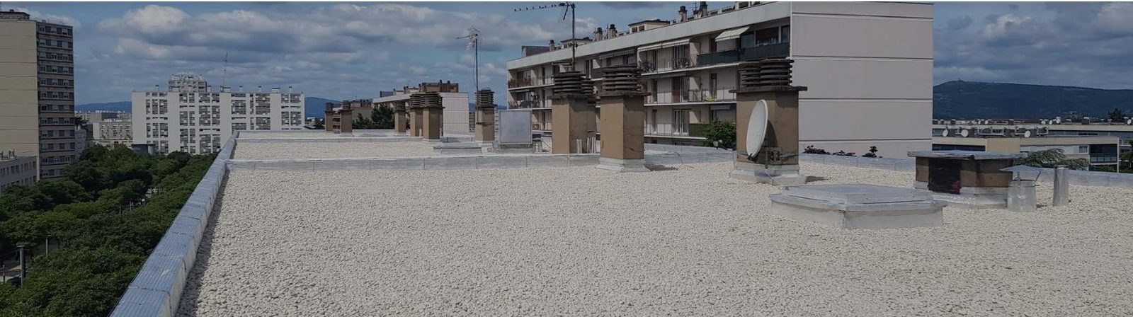 Panorama d'une toiture-terrasse gravillonnée refaite en milieu urbain