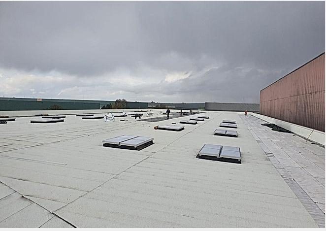 Grande toiture-terrasse en membrane bitume avec lanterneaux